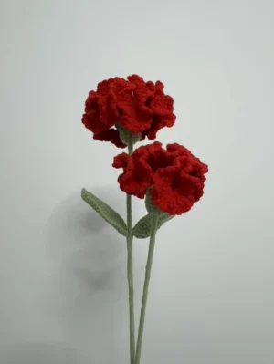 Crocheted red carnations with green leaves.