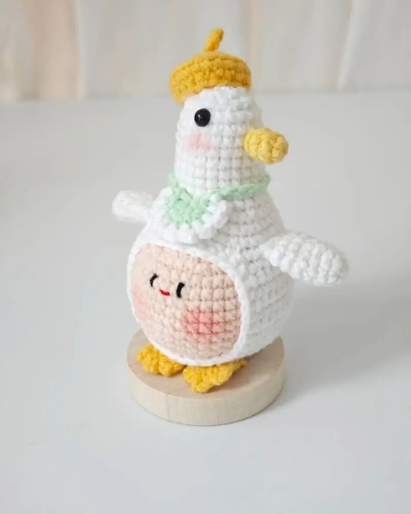 Crocheted bird doll, white, yellow beret, light green scarf.