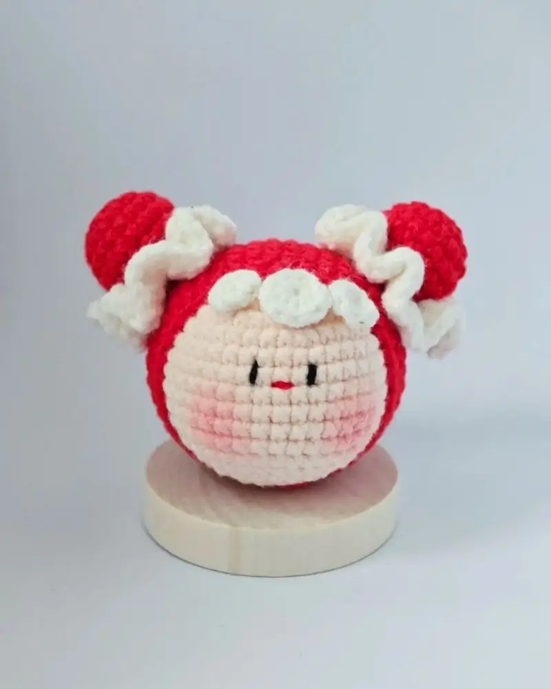 Crocheted red and white doll, cute character.