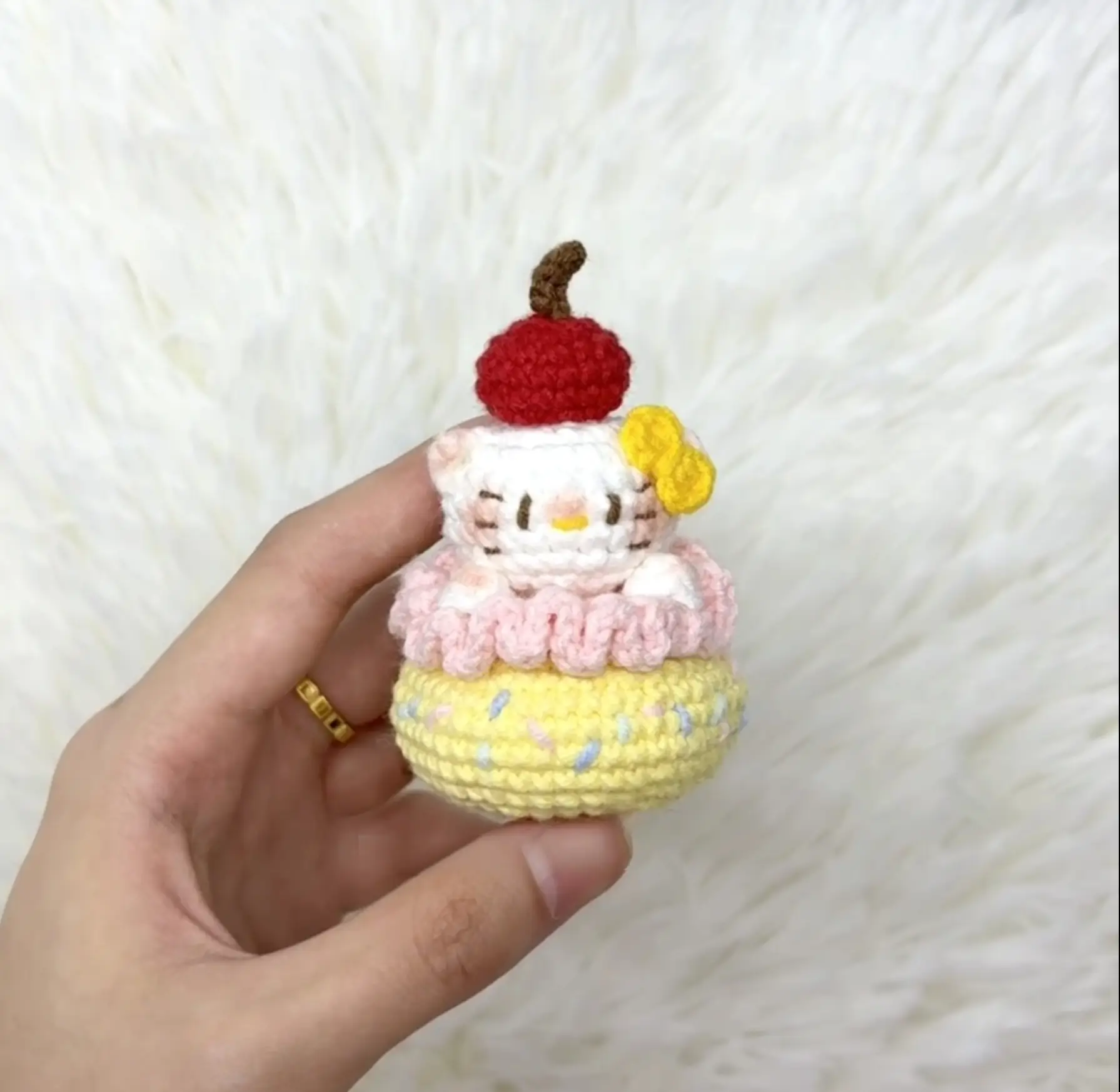Crocheted Hello Kitty cupcake, layered pastel colors.