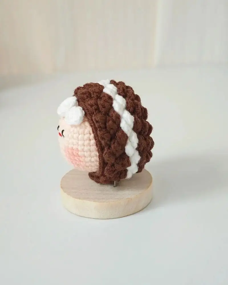 Crocheted doll head, brown hair with white stripes,  cute face.