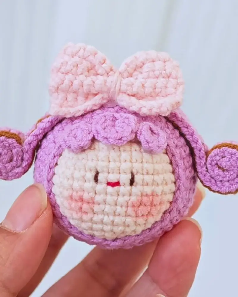 Crocheted,  pink bow, purple doll.