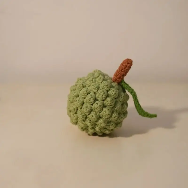 Crocheted green fruit, likely a durian.