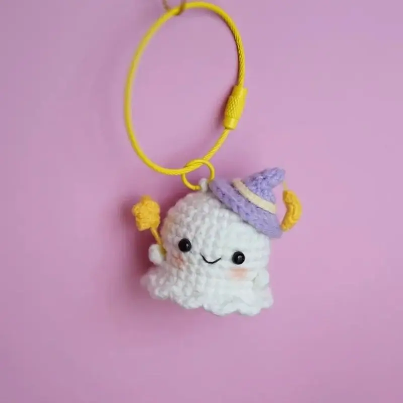 Cute crocheted ghost keychain, purple hat, yellow accessories.