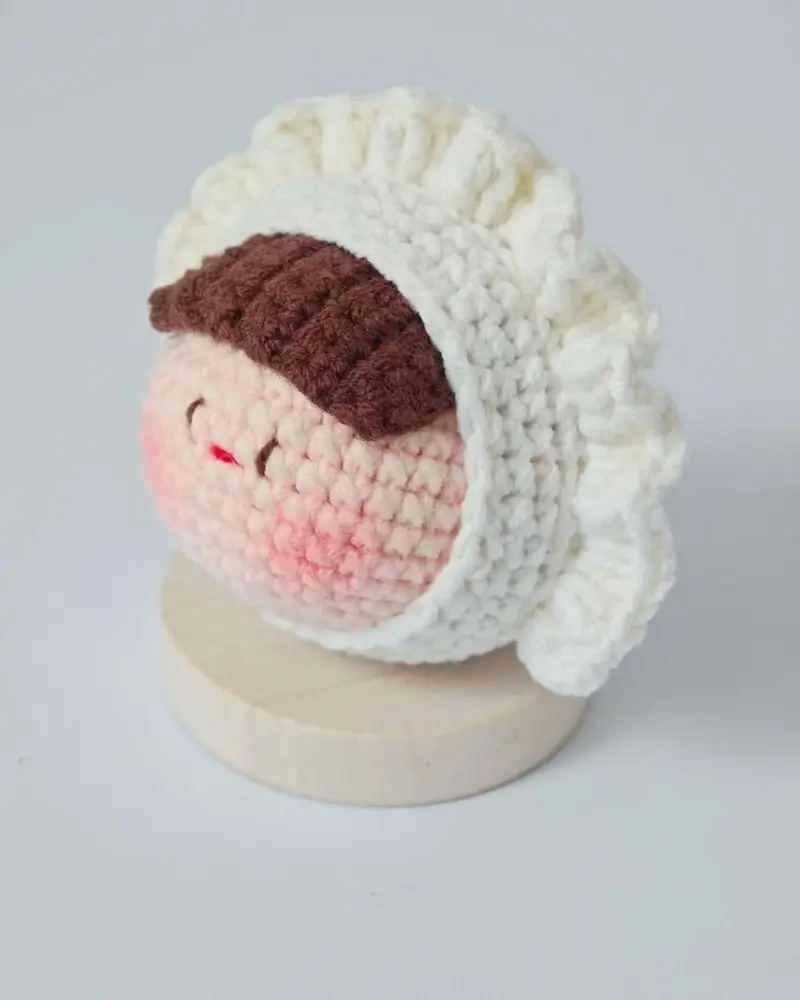 Crochet doll,  white bonnet, brown hair.