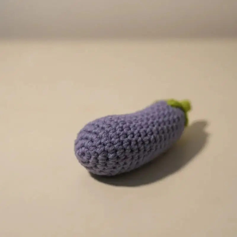 Crocheted purple eggplant toy.