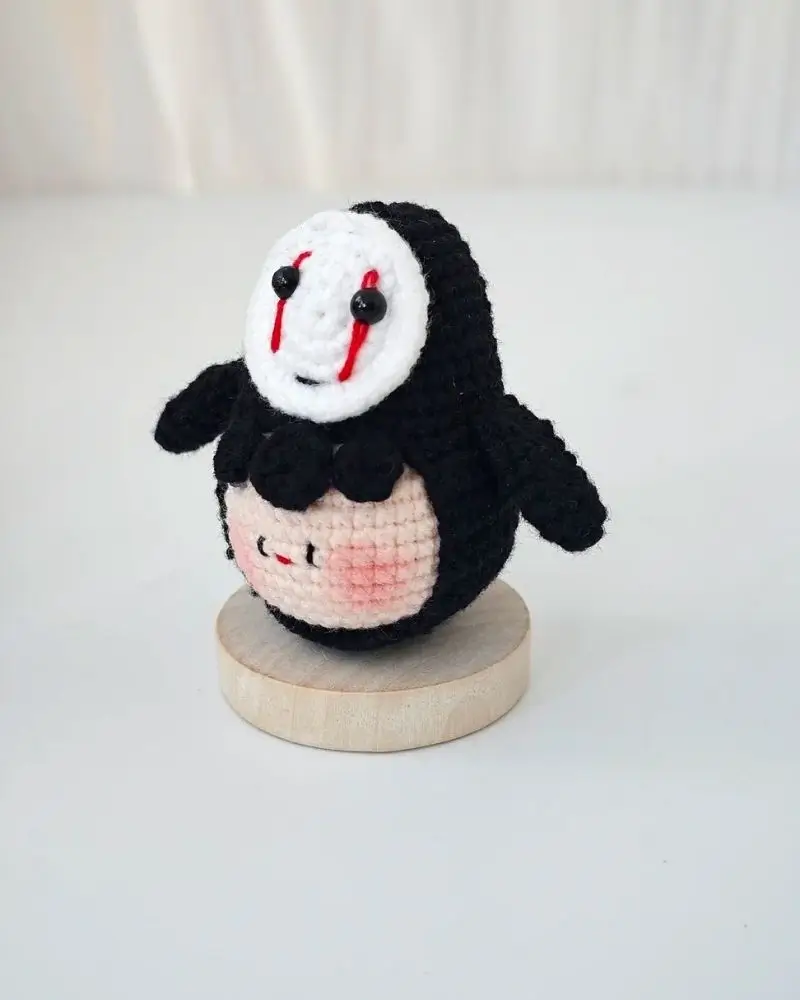 Crochet doll, black, white face, red tears.