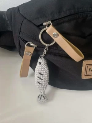 Crochet fish keychain on black bag.