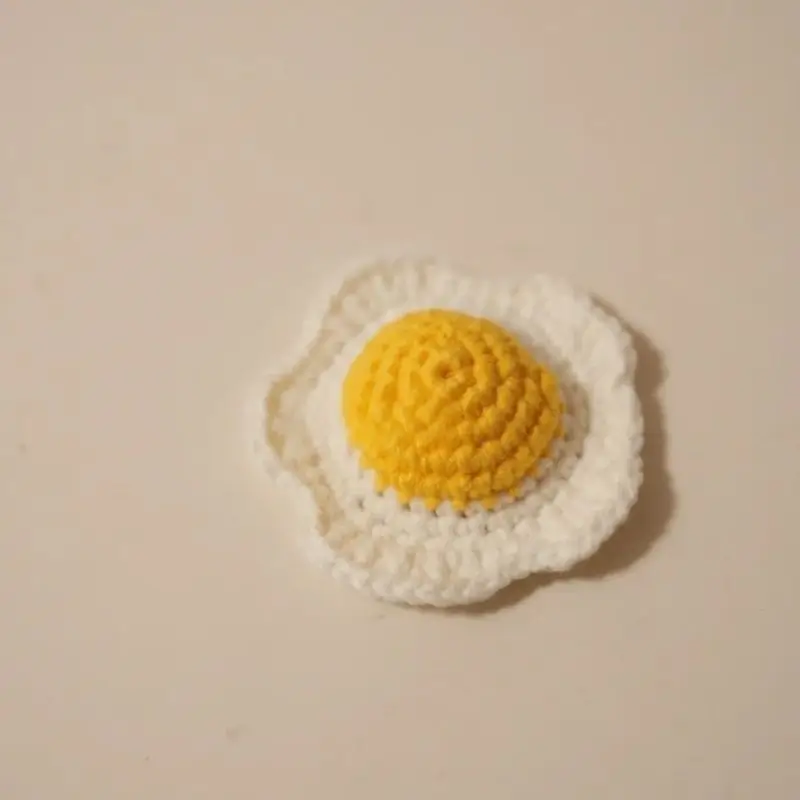 Crocheted fried egg, yellow yolk, white egg white.