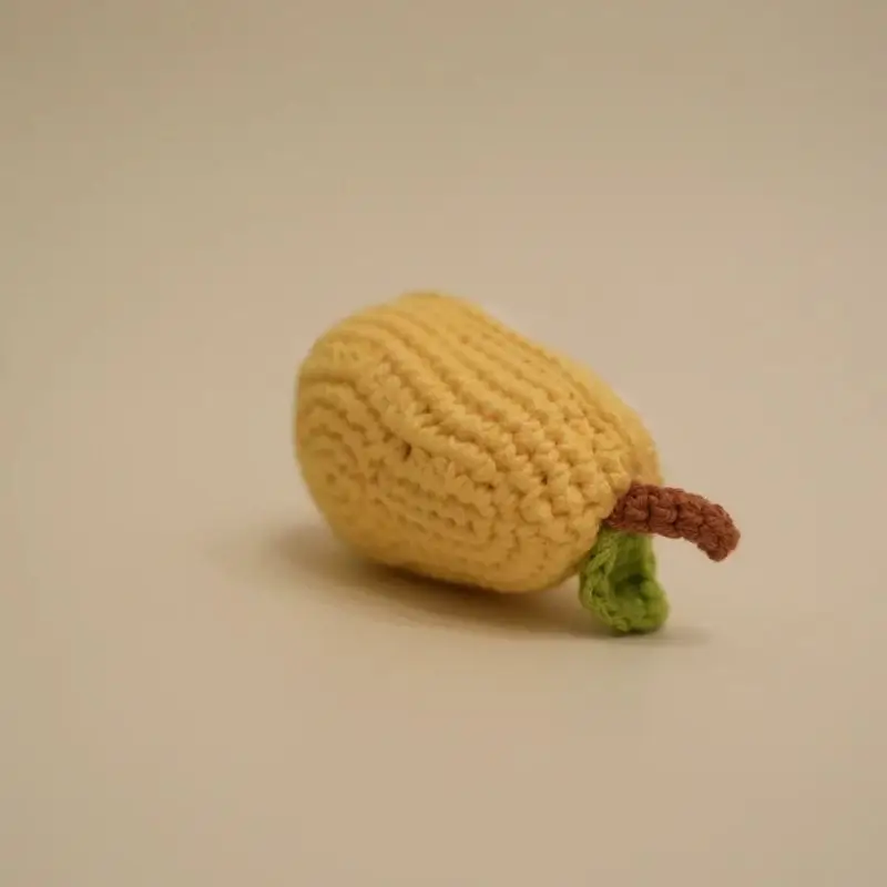 Crocheted yellow pear toy.