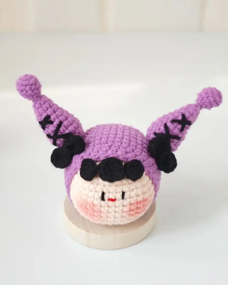 Crocheted purple doll, black accents.