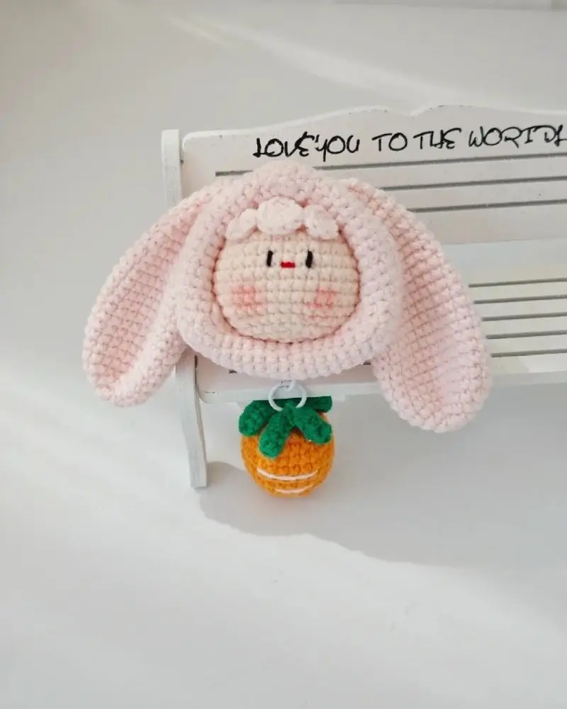 Pink crocheted bunny keychain with carrot.