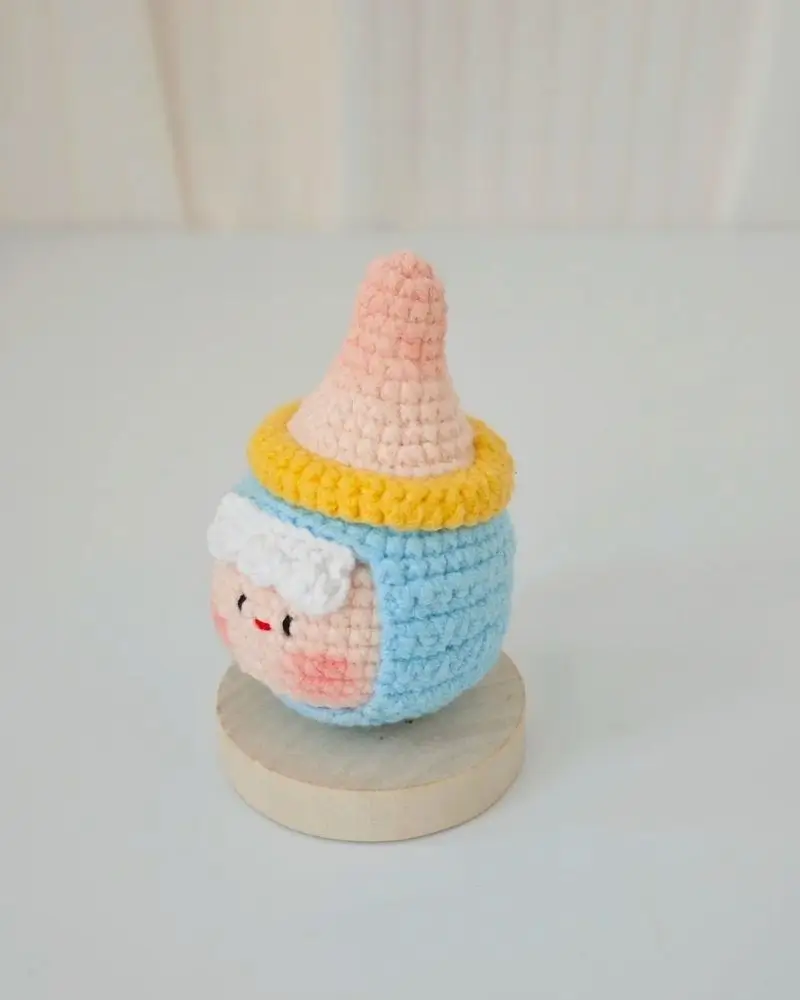 Cute crocheted figurine, light blue, pink, and yellow.
