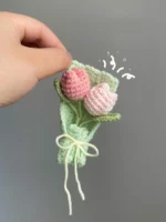 Crocheted bouquet of pink tulips in a green wrap.