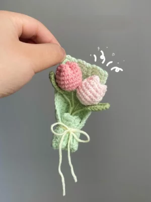 Crocheted bouquet of pink tulips in a green wrap.