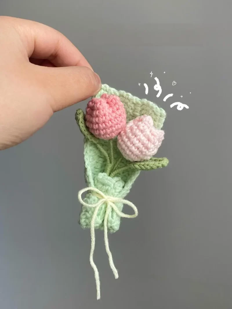 Crocheted bouquet of pink tulips in a green wrap.