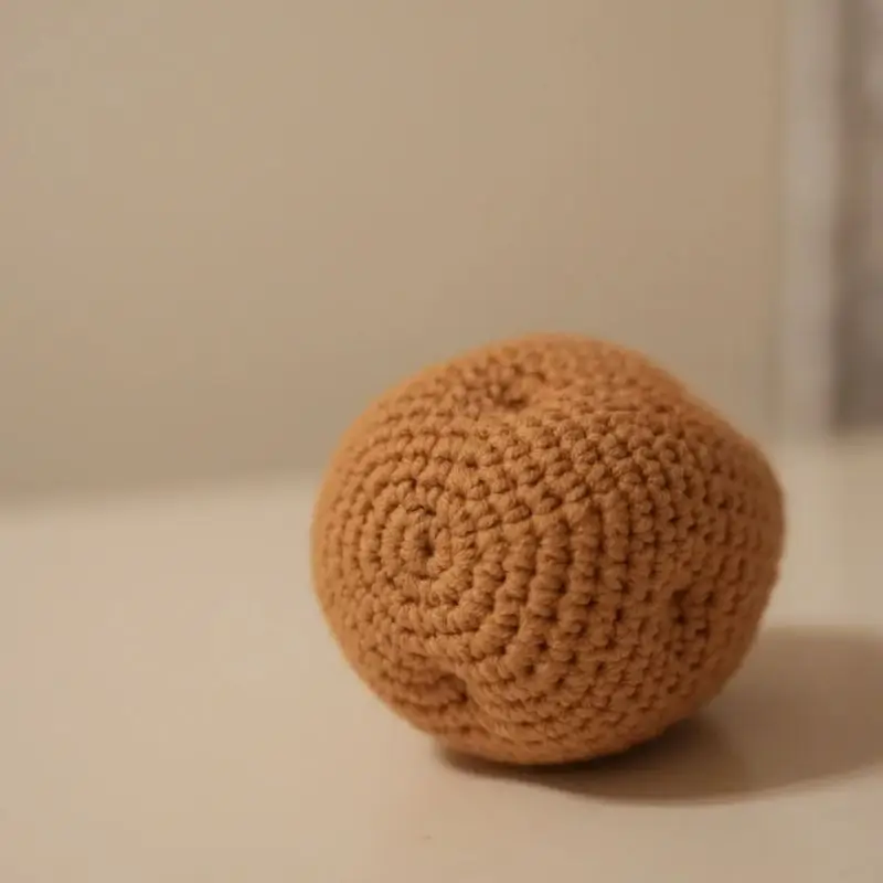Crocheted, light brown, round object.