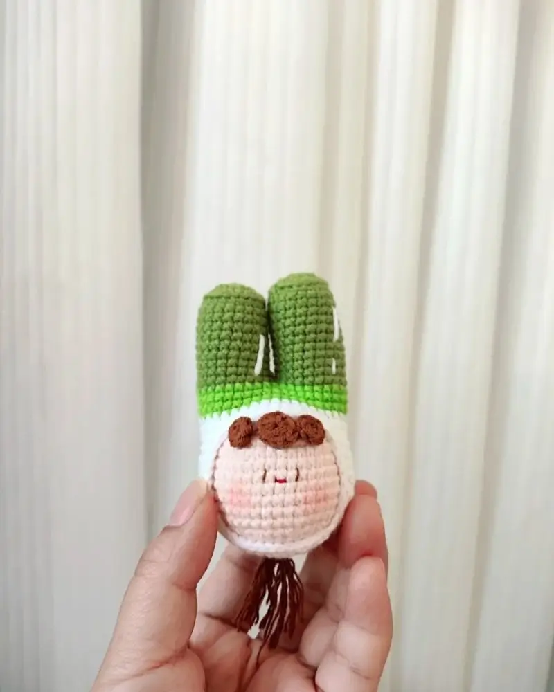 Crocheted bunny with green cactus ears, cute face.