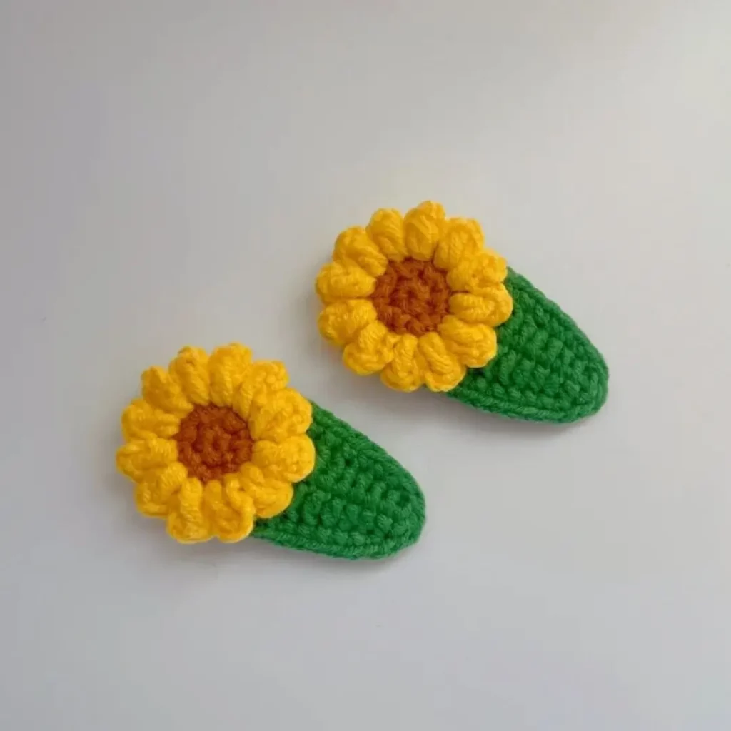 Two crocheted sunflower hair clips.