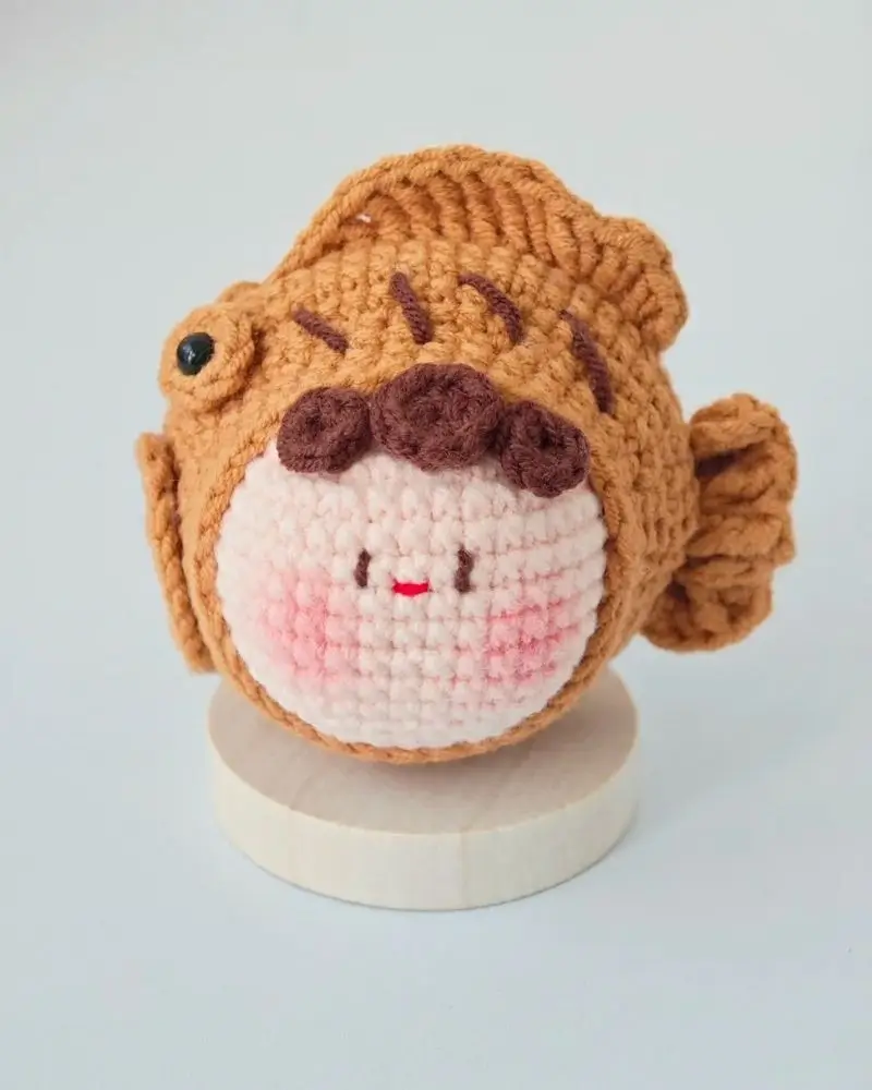 Cute crocheted taiyaki fish, cartoon style.