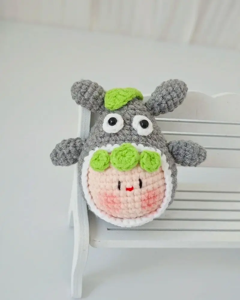 Cute gray crocheted sheep amigurumi toy with green accents.