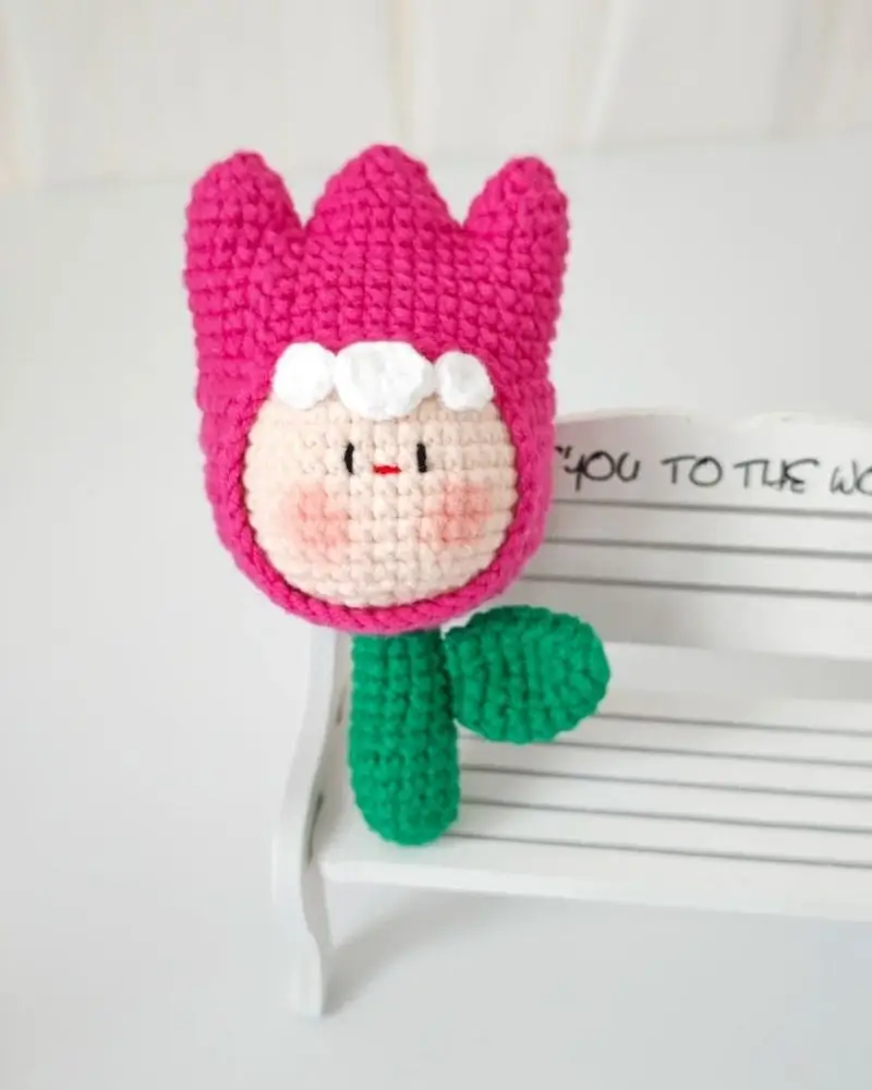 Pink crocheted flower-shaped amigurumi.