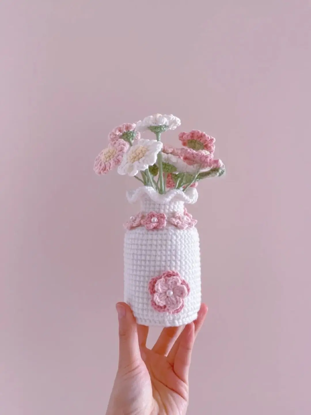 Crocheted flowers in pink and white, in a vase.