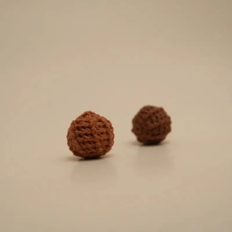 Two small, brown, knitted balls.