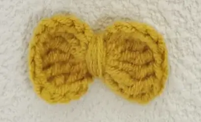 Mustard yellow crocheted bow.