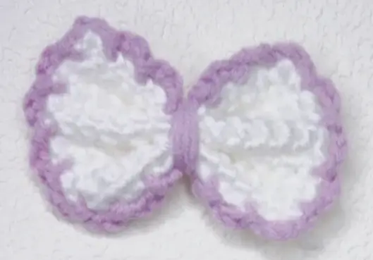 Crochet bow, purple trim, white center.