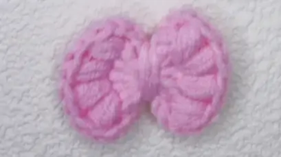 Two light pink crocheted flower shapes.