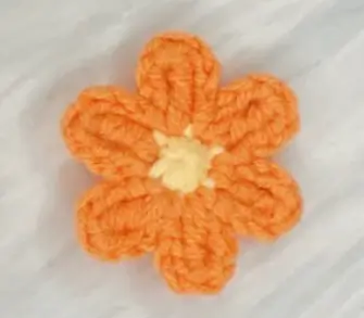 Orange crocheted flower, delicate design.