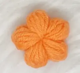 Small, knitted, coral-orange flower.