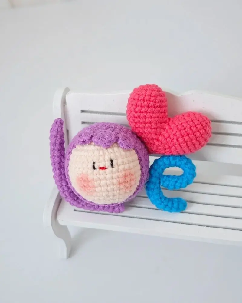 Crochet "love"  letters,  pink heart, purple character.