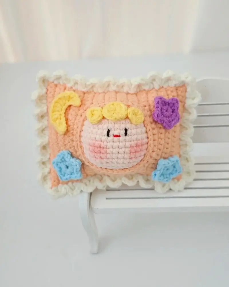 Crocheted pillow, pastel colors, cute face.