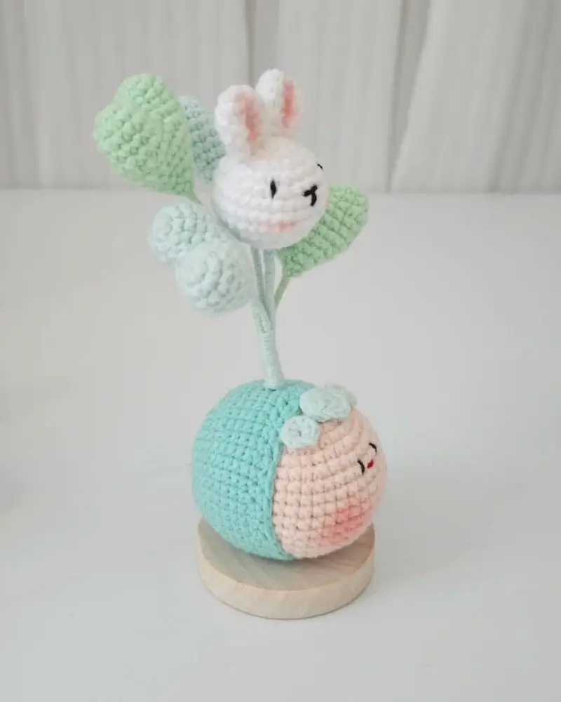 Crocheted bunny and plant, pastel colors.