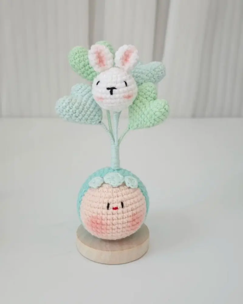 Cute crocheted bunny on a heart-shaped balloon tree, with a round character base.  Small amigurumi.