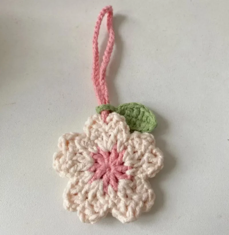 Crocheted cherry blossom charm, pink and cream.