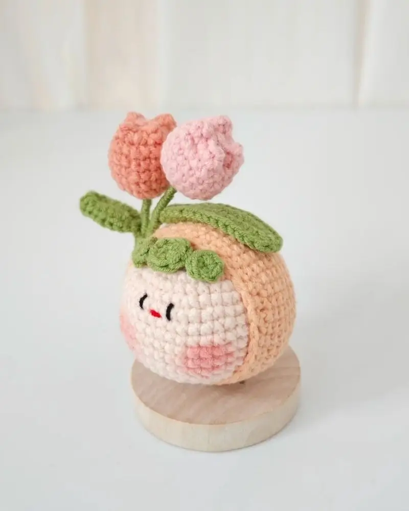 Crocheted flower pot, peach colored, pink tulips, cute face.