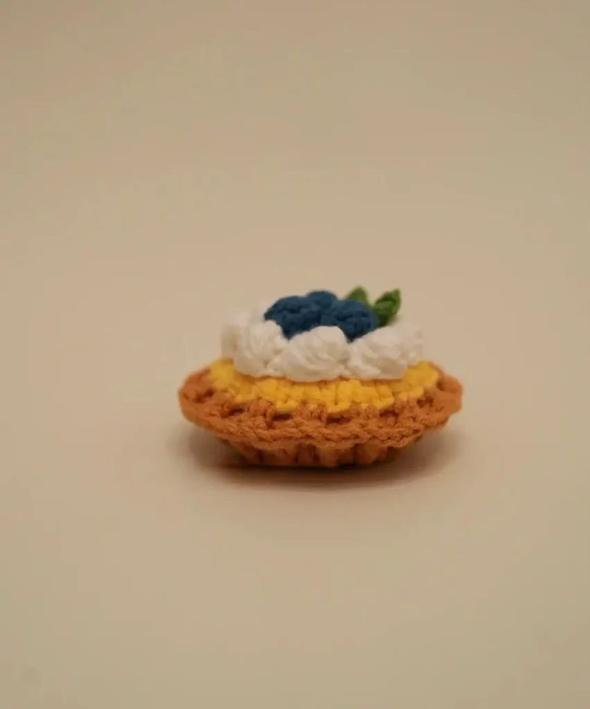 Crocheted blueberry tart.  Small dessert.