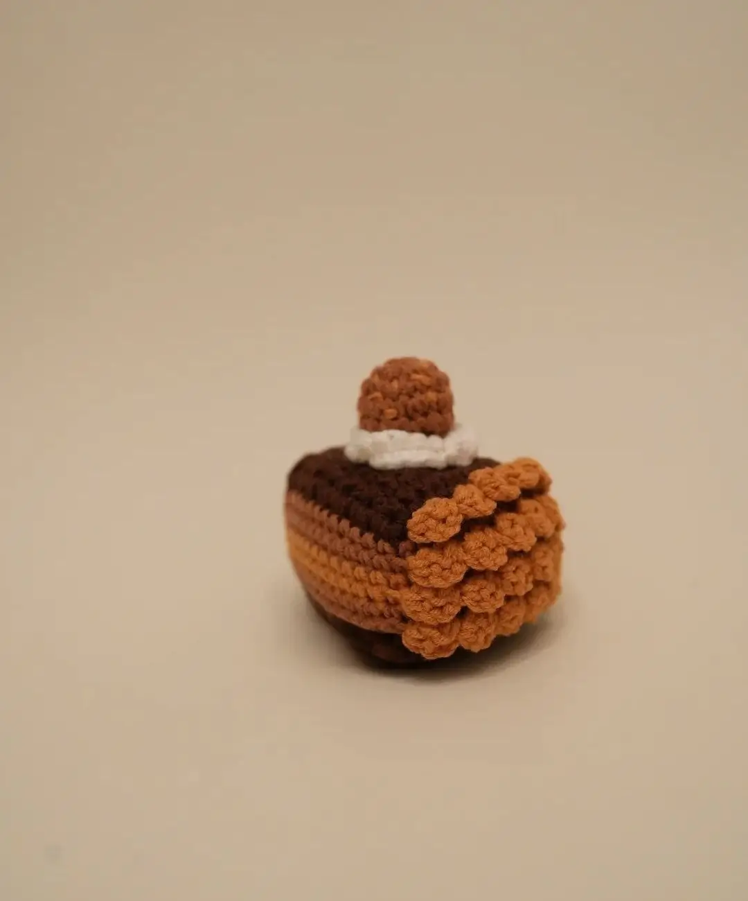 Crocheted layered cake, brown and orange.