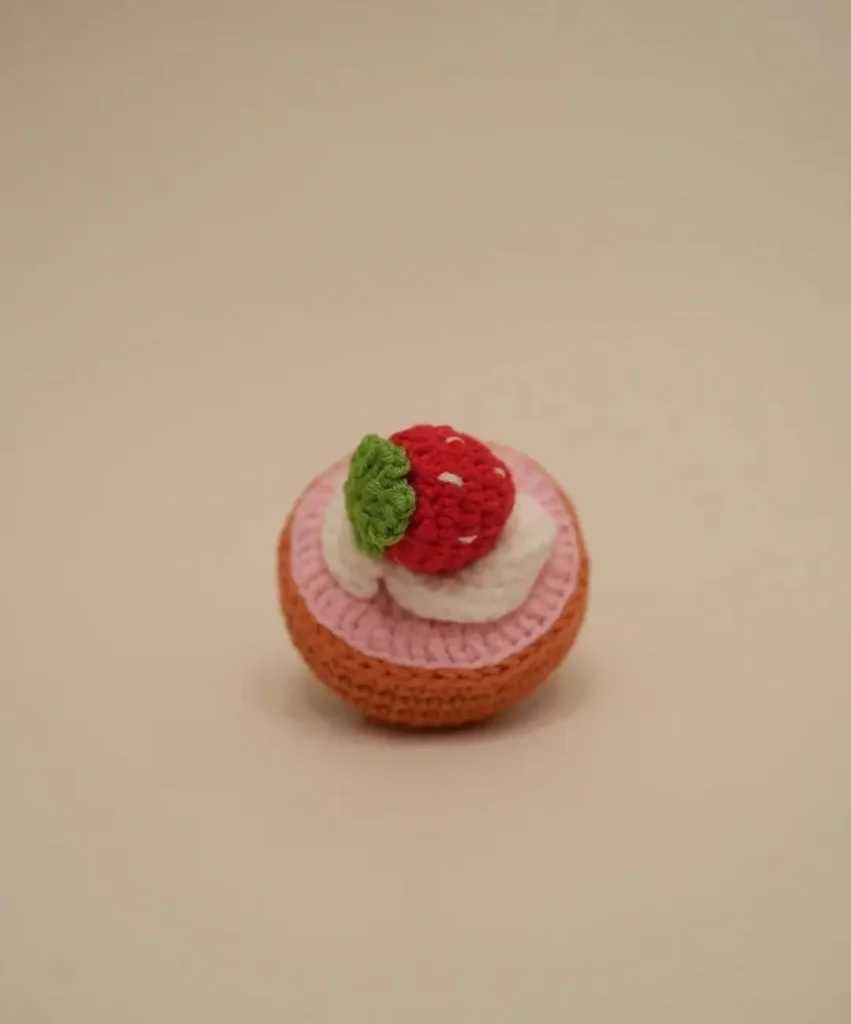 Crocheted strawberry cake toy.