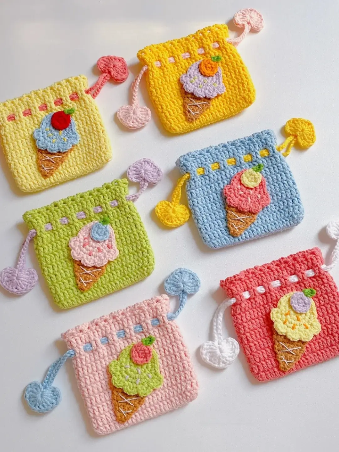 Colorful crocheted ice cream cone pouches, various pastel colors.