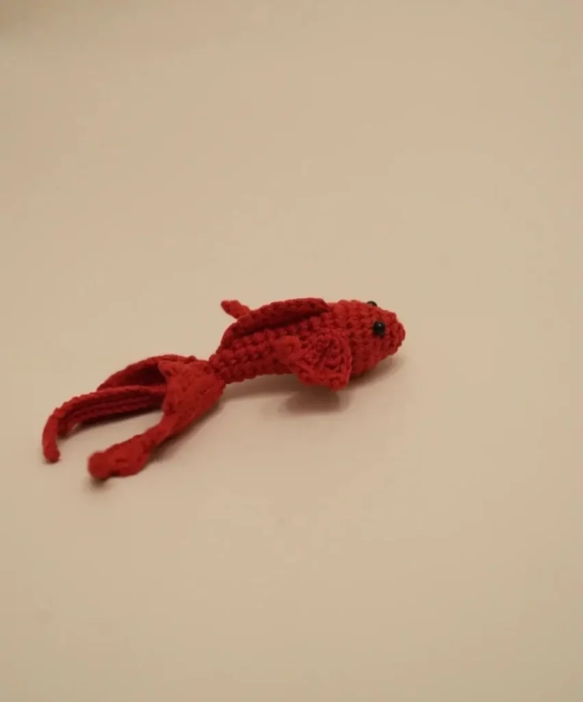 Crocheted red fish toy.