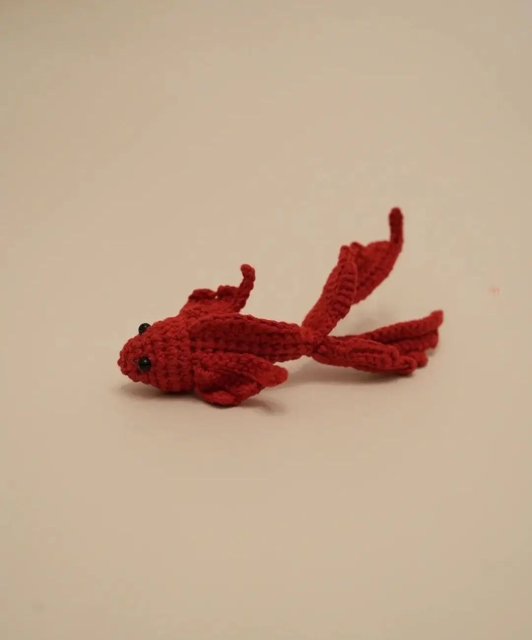Red crocheted fish toy.