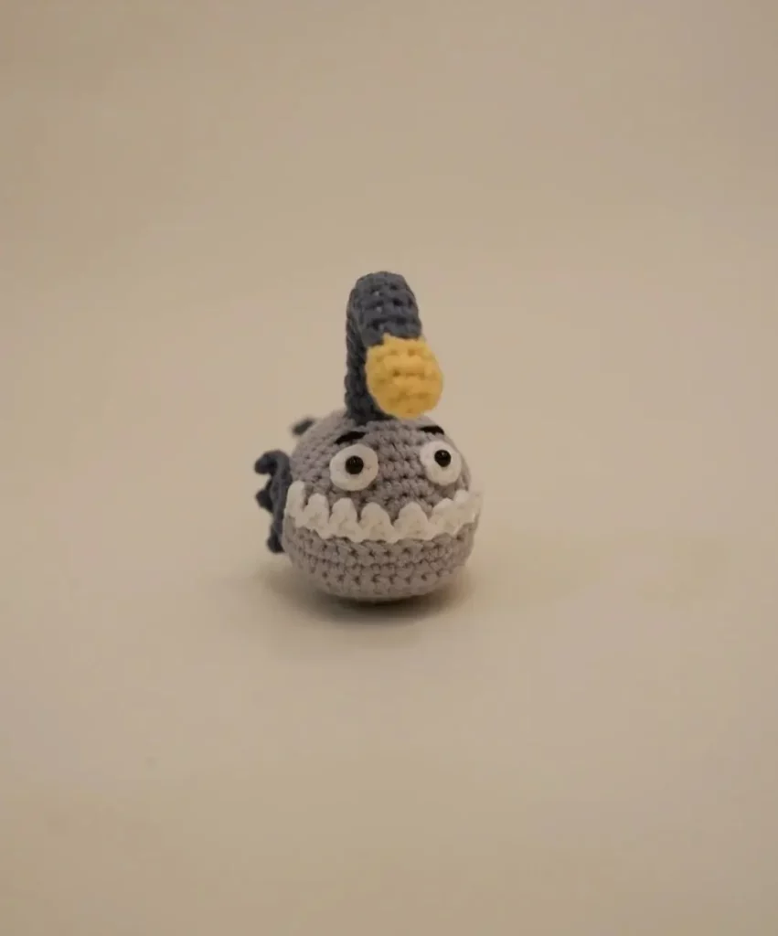 Crocheted grey fish toy, cute, whimsical.