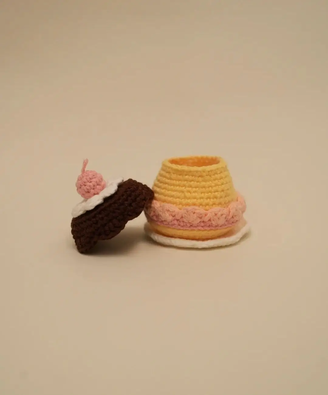 Crocheted cupcake and cake, yellow, brown, pink.