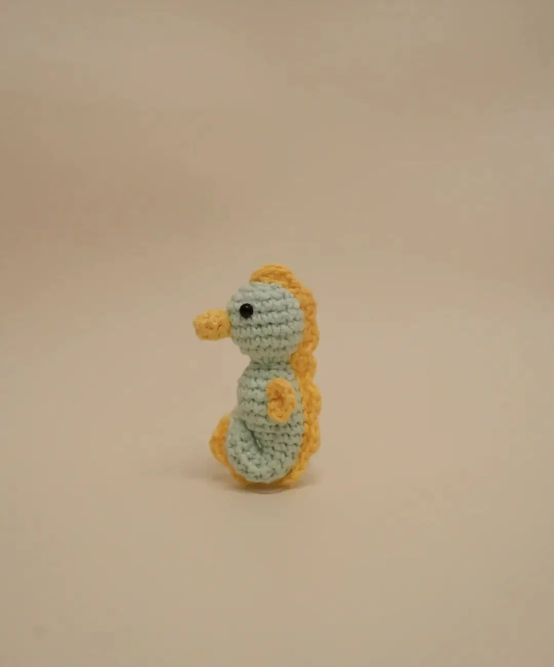 Crocheted seahorse, light blue, yellow details.