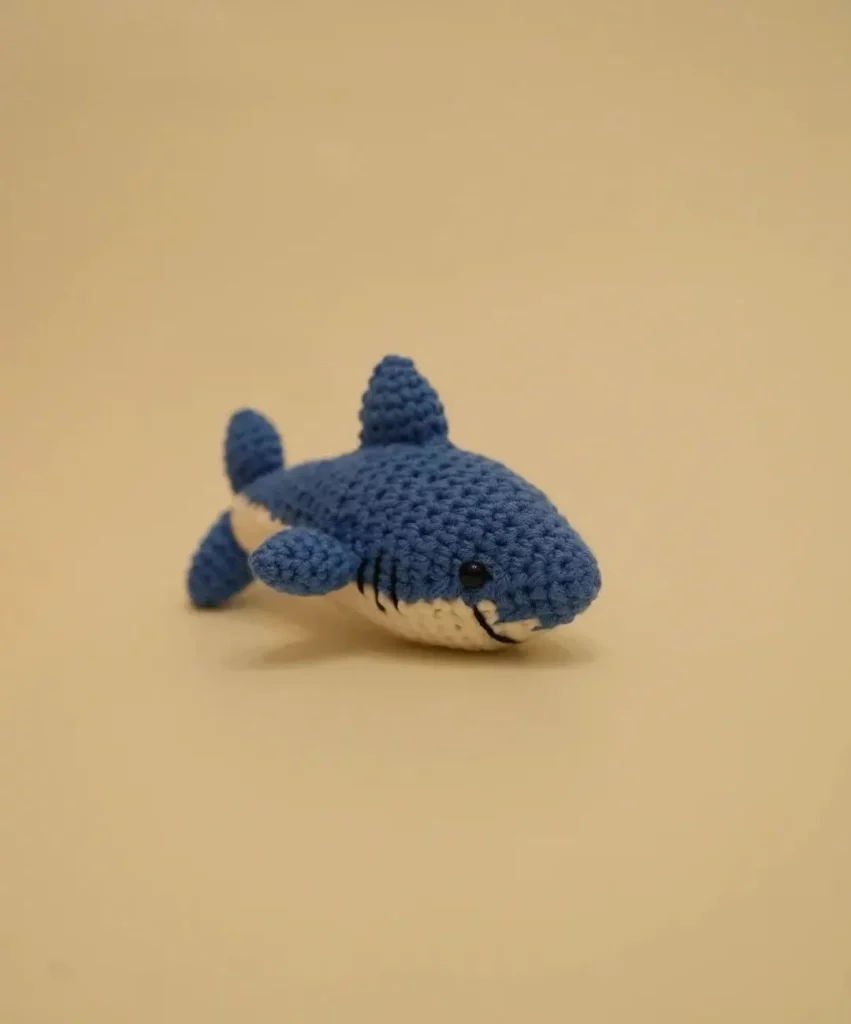 Blue crocheted shark toy.