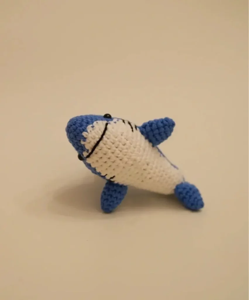 Crocheted blue and white shark toy.